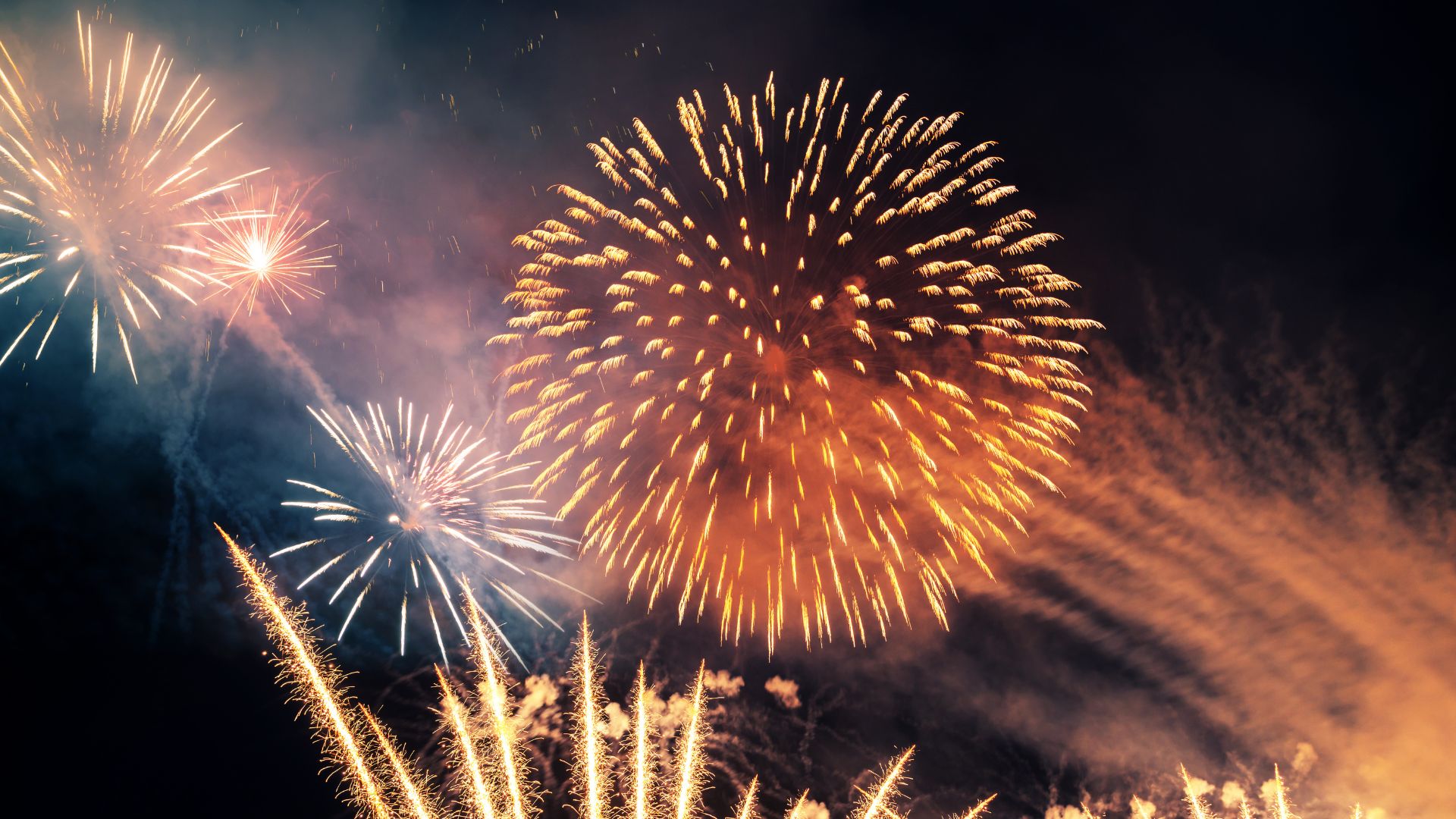 ALT描述: 黑色背景下綻放的巨大圓形金黃色煙火，四周伴隨細碎的金色火花。