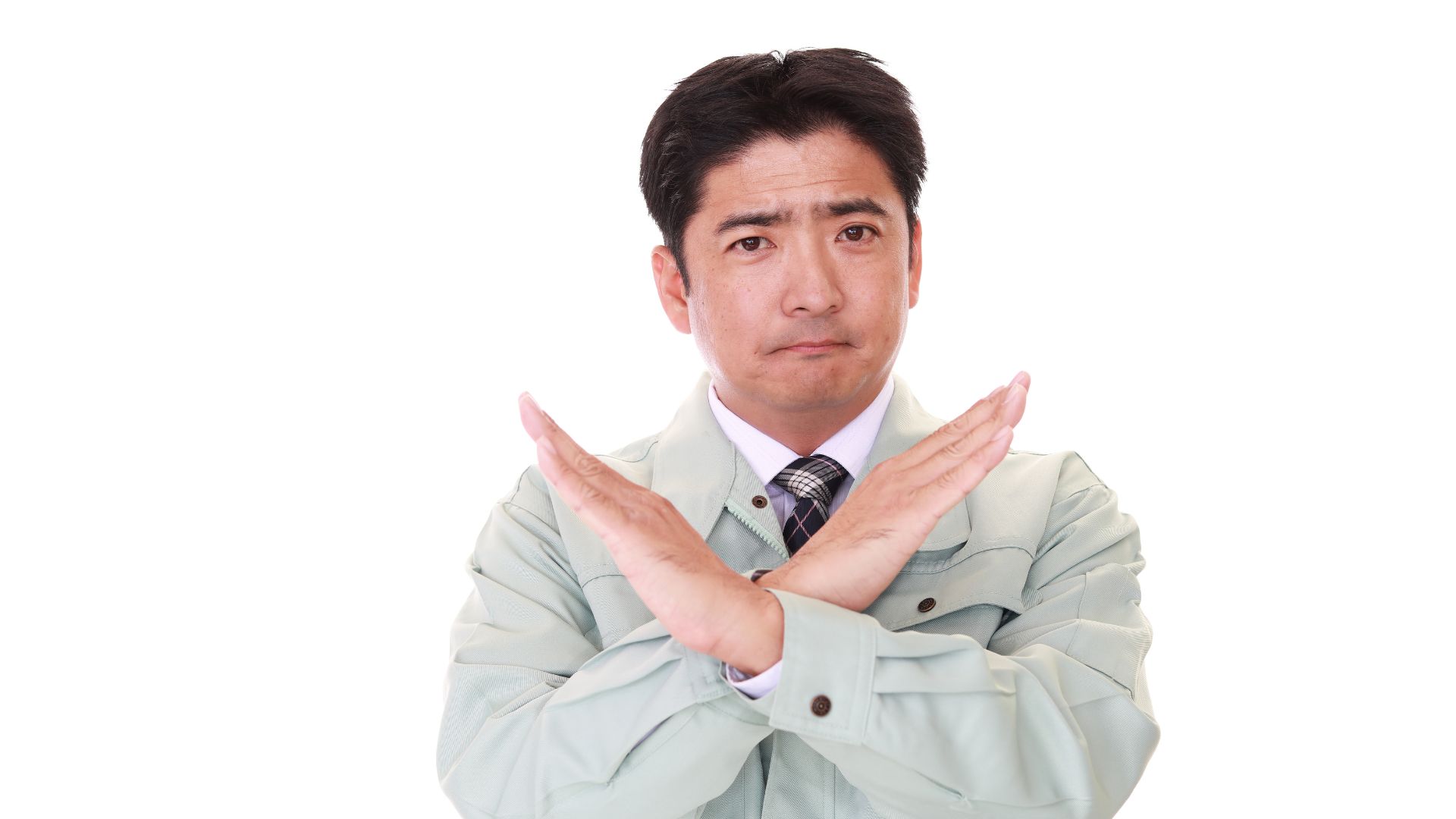 ALT描述: 一名穿著工作夾克與領帶的男士，雙手在胸前交叉呈「X」型姿勢，表情嚴肅，明確表達拒絕、禁止或錯誤的意思。
